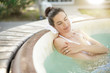 © goodluz - Attractive brunette woman relaxing in jacuzzi