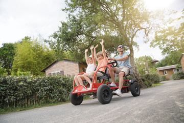 Wall Mural - Parents with kids having fun riding kart