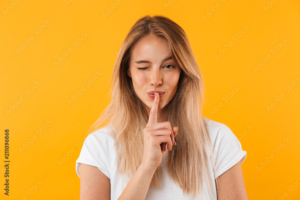 Portrait of a pretty young blonde girl showing silence gesture - obrazy, fototapety, plakaty 