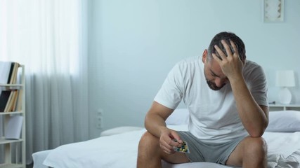Upset man starts taking medicines to treat desease, midlife crisis problem