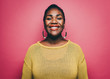 © Maskot - Portrait of smiling mid adult woman against pink background