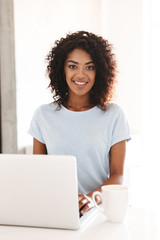 Poster - Happy african woman using laptop computer