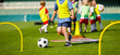 © matimix - Kid Young Athletes Training with Football Equipment. Football Speed and Agility Training. Young Footballer in Blue Sportswear at Training Session on Grass Soccer Field
