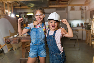 Wall Mural - Two young girls doing woodwork in a workshop
