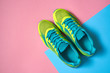 Pair of sport shoes on colorful background. New sneakers on pink and blue pastel background, copy space. Overhead shot of running shoes. Top view, flat lay