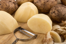 Raw Peeled Potatoes On A Wooden Board