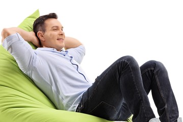 Wall Mural - Relaxed young man sitting on a beanbag