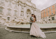 Bride And Groom Posing In Front Of Trevi Fountain (Fontana Di Trevi), Rome, Italy