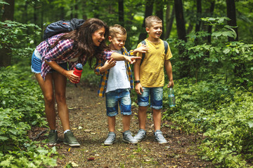 Wall Mural - mother and her little sons hiking trough forest .