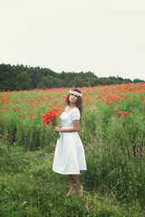 Wall Mural - Beautiful woman in field with a lot of poppy flowers