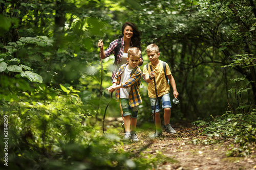 Fotografía Mother and her little sons hiking trough forest .