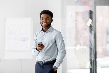 Poster - business, people and technology concept - african american businessman with smartphone at office