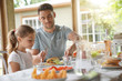 © goodluz - Portrait of man with little girl eating lunch together