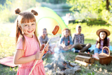 Wall Mural - little girl with fried sausage outdoors. summer camp