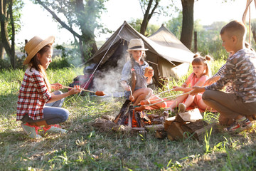 Wall Mural - little children frying sausages on bonfire. summer camp