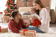 © New Africa - Happy couple with baby celebrating Christmas together at home