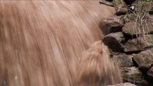 Close-Up: Rushing Dirty Water Past Rock Formation