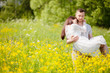 © Alinsa - Couple walking in the yellow meadow, man keeping a woman in his arms