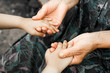 Hands of a little girl and an old grandmother. Hands of a little kids holding elderly man, World Kindness Day concept