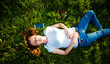 © Melinda Nagy - woman lying in grass listening to music - summertime relaxation
