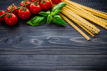 Italian pasta spaghetti and tomatoes with herbs on a wooden table