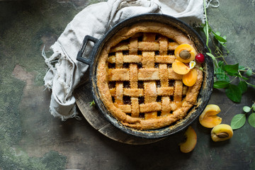 Fruit pie on colorful wooden rustic background with fresh peaches