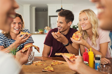 Friends eating pizza at home