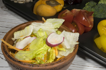 Wall Mural - salad in a salad bowl of vegetables is on the background of fruits and vegetables