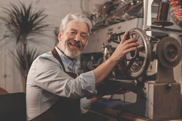 Wall Mural - Smiling elderly man in a workshop