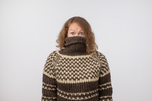 Woman In Warm Brown Sweater Hiding Her Face. Only Eyes Are Seen. She Wants To Stay Anonym.