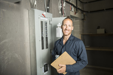 Man Technician servicing at work on electric room