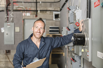 Wall Mural - Man Technician servicing at work on electric room