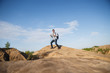 © snedorez - Image from afar of tourist man with walking sticks on mountain hill