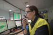 © goodluz - Woman in industrial control room using radio to give instructions