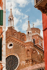 Wall Mural - Santa Maria Gloriosa dei Frari Basilica (St. Mary of the Friars) with gothic pinnacles, the biggest church in Venice, completed in the 15th century, seen from a narrow street in the historic center