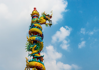 traditional Chinese golden dragon pillar with blue sky and cloud background