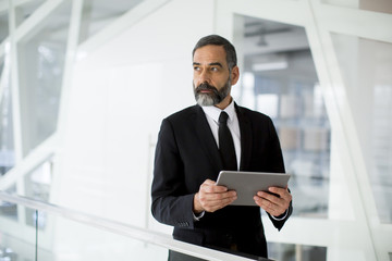 Wall Mural - Middle age businessman with tablet in the office