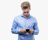 Fototapeta Na ścianę - Young handsome blond man using smartphone with a confident expression on smart face thinking serious