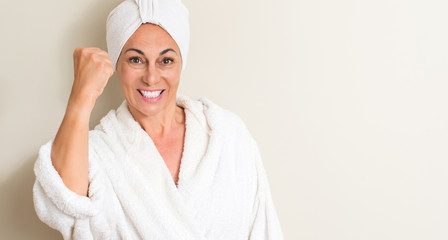 Poster - Beautiful middle age woman, wet hair wearing a towel annoyed and frustrated shouting with anger, crazy and yelling with raised hand, anger concept