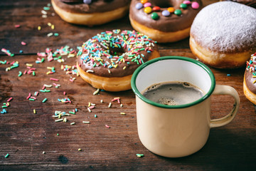 Wall Mural - Coffee donuts and krepfen, sprinkles and powder sugar, many on wooden table background.