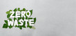 zero waste paper text witj green leaves on gray background