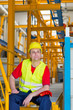 © Marko Rupena - Worker in yellow reflective suit with yellow helmet sitting in a factory
