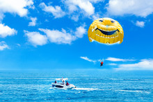 Parasailing Water Amusement. Flying On A Parachute Behind A Boat On A Summer Holiday By The Sea In The Resort. 