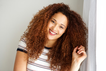 attractive mixed race woman with curly hair smiling