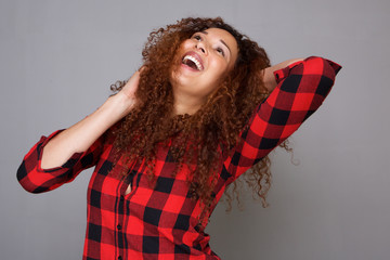 Wall Mural - young hispanic woman laughing against gray backgorund