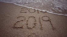 New Year Concept - ‘2019’ Formed On Background Of Beach Sand. With Blurred Vintage Styled Background.