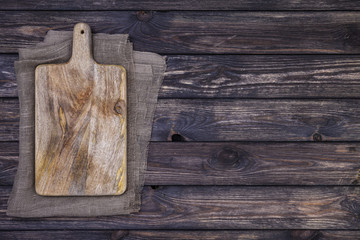 Wall Mural - Old cutting board on dark wooden table. Top view. Copy space
