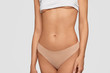 © wayhome.studio  - Perfect slim body, elastic belly and healthy skin. Sporty female in white top and beige pants, shows fit figure after sport training. Advertisement of lingerie for women. Motivation concept.