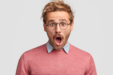 Poster - Stressed hipster male has shocked expression, realizes that his car is stolen, keeps mouth widely opened, stares through round spectacles, isolated over white background. People and emotions concept