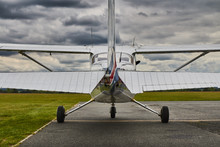 Symmetrical Rear View Of Cessna 172 Skyhawk 2 Airplane On A Runway With Dramatic Sky Background.